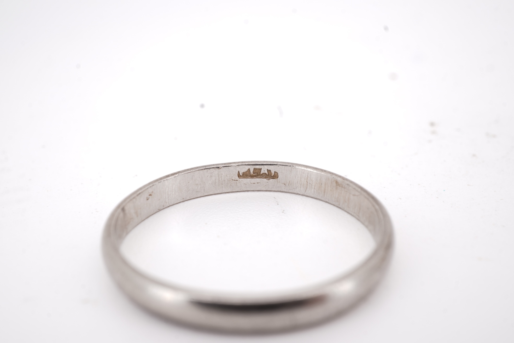 Three rings, comprising: a platinum wedding band, size N1/2, stamped PLAT, gross weight 3 grams; a bicoloured band, size J, stamped PLATINUM 22CT, gross weight 3 grams; and a ring set with a diamond weighing approximatel